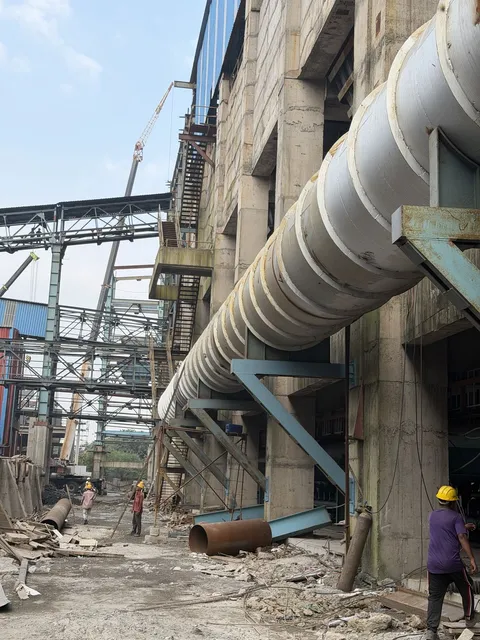 Large insulated duct running along the side of a plant building