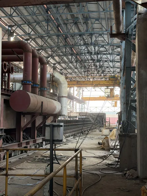 Plant shed interior with piping and an overhead crane