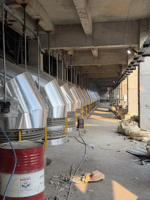 Row of steel chutes and hoppers inside a plant building
