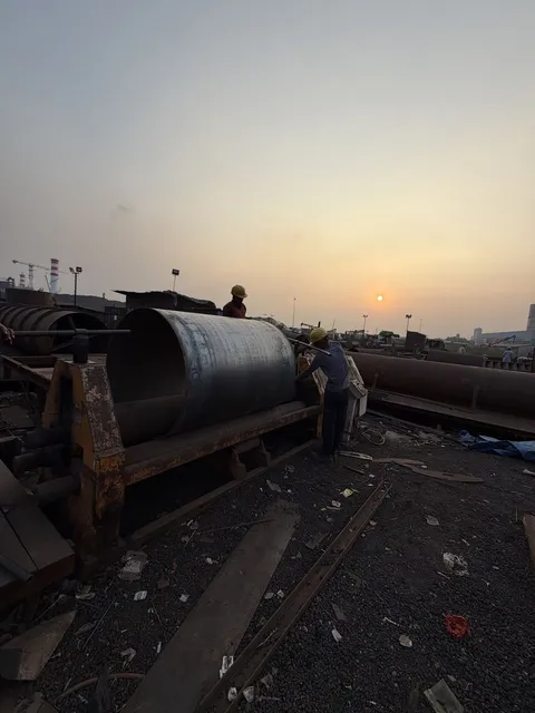 Large steel cylinder at a fabrication site at sunset